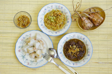 Rice cakes together with beef stew, chayote soup, unpeeled rice cakes and dried onion ares served  captured top view. 