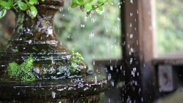 Water Drops and droplets from clay pot in tropical green garden slow motion 120 fps