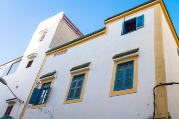 Fototapeta na wymiar Open window with blue shutters shutters against a white wall