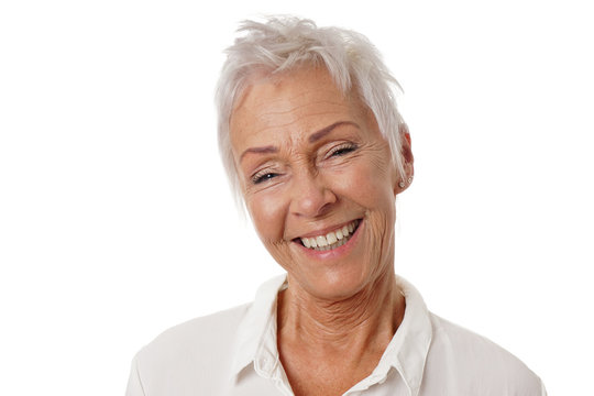 happy older woman with trendy short white hair and toothy smile. isolated on white