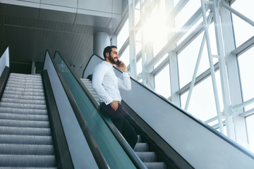 Business Man Talking On Mobile Phone In Office On Stairs
