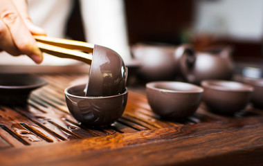 Tea ceremony, woman cleaning teacup with boiled water