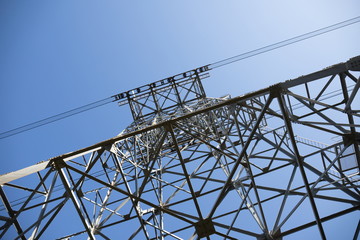Looking up ropeway pylon against blue sky