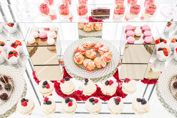 Candy bar with a lot of desserts, meringue, cupcake, fruit and sweet cakes. Sweet table for birthday or wedding.