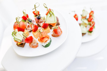 Assortment of canapes. Banquet service in restaurant . Catering food, snacks on white plate
