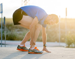 Runner touching painful twisted or broken ankle.