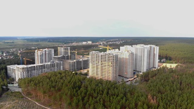 Building a city in the forest. Aerial survey of construction of a residential complex