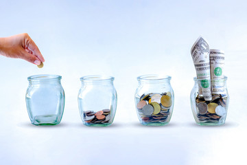 Saving  money. A hand putting money in bottle on White background. The coins in the bottle for save money. Photo financial saving and  Saving  money.