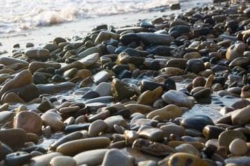 Obraz premium pebble stones on the sea beach, the rolling waves of the sea with foam