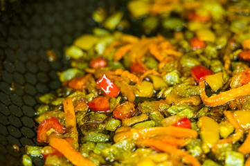 cooking a roast for soup of onions, carrots, paprika, tomatoes, herbs and spices in sunflower oil in a frying pan