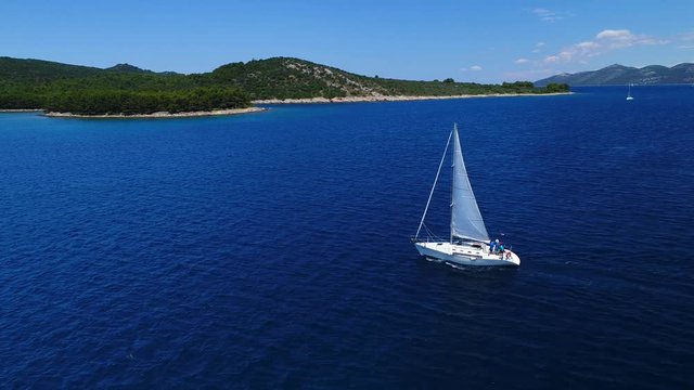 Yacht in amazing blue sea, taken from top in 4k by drone