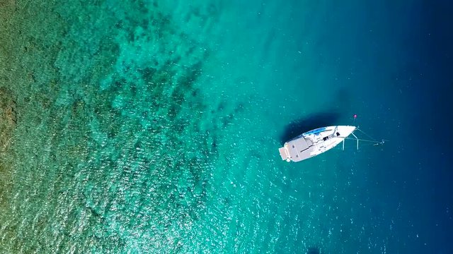 Yacht in amazing clear sea, taken from top in 4k by drone