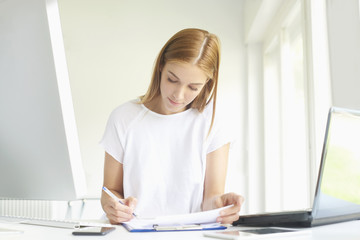 Confident young businesswoman working at office desk. Home office 