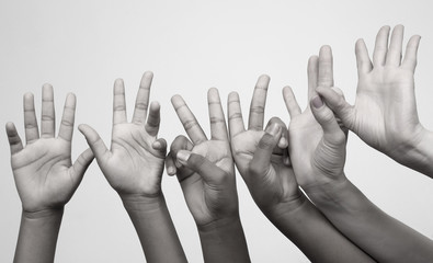 many raised children's expressive hands in a row