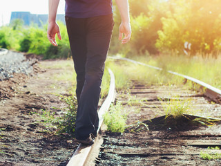 A man walks the rails in the sunlight