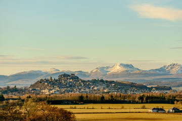 View of the Stirling Castle and the old town in winter with the mountains in the background.