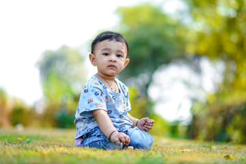 cute indian baby boy playing at garden