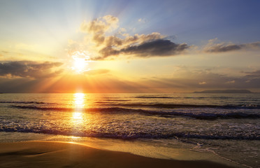 Fototapeta na wymiar Golden sunrise sunset over the sea ocean waves. Rich in dark clouds, rays of light