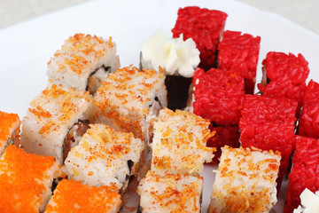 Sushi on a light background, close-up. With caviar of flying fish. Fresh colored sushi.