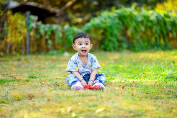 cute indian baby boy playing at garden