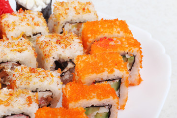 Sushi on a light background, close-up. With caviar of flying fish. Fresh colored sushi.