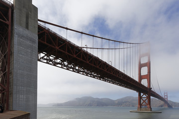 Obraz premium Cloudy midday in Golden Gate Bridge, seen from above of Fort Point. The Golden Gate Bridge is a famous suspension bridge connecting the American city of San Francisco, California to Marin County.