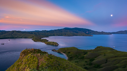 A Full Moon and A First Rays of Rising Sun in Pink Color At Gili Lawa with Clear Sky and Blue Sea. Komodo National Park, Labuan Bajo, Flores, Indonesia © Pnnchen