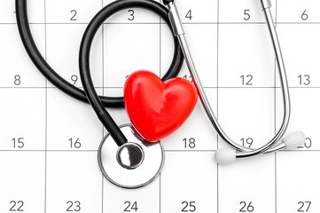 Calendar with stethoscope and red heart. Date for medical examining. Top view.