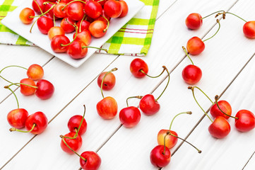 Fototapeta na wymiar Cherries and saucer with cherries on the table.
