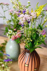 Bouquets of summer wild flowers in ceramic vases.