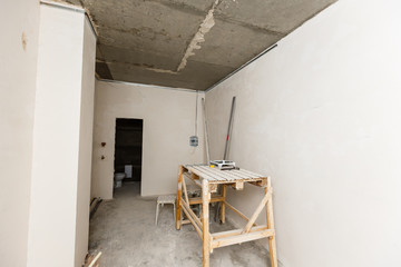 Construction grunge ladder, and the building yellow level : white wall and gray floor. Apartment decoration concept.