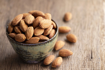 Almonds in a bowl on the wood table.