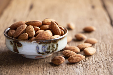 Almonds in a bowl on the wood table.