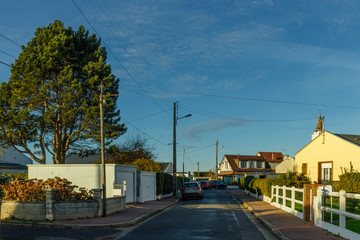 Country houses with fences and streets in the region of Normandy, France. Beautiful countryside, lifestyle and typical french architecture, european country landscapes