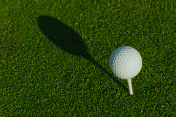 Golf ball on the green course. Close up. Top view. Sport, relax, recreation and leisure concept