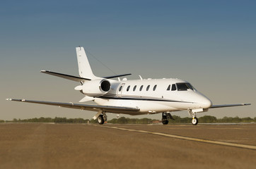 Fototapeta na wymiar Modern private business jet ready to take off with blue sky at the background