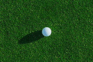 Golf ball on the green course. Close up. Top view. Sport, relax, recreation and leisure concept