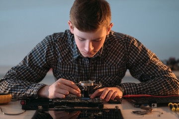 electronic renovation in repair shop. engineer working with disassembled motherboard