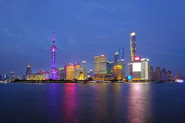 Obraz na płótnie Canvas Shanghai city skyline Pudong side looking through Huangpu river on twilight time. Shanghai, Chima. Beutiful vibrant panoramic image.