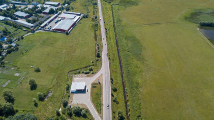 Drone Photo of the Crossroad Between Trees in Colorful Early Spring - Top down view with Freshly Cultivated Field on the one side and Dandelion Field on the Other Side