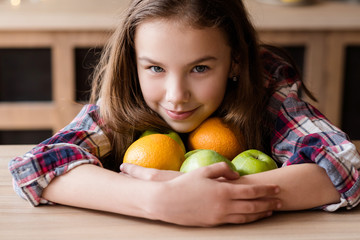Fototapeta premium healthy fruit snacks for kids. wholesome diet and natural organic food for children development. girl holding a mix of oranges and apples in hands