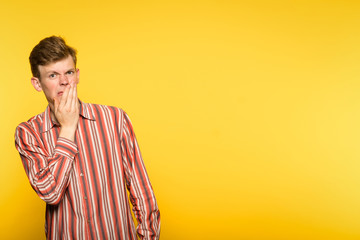 squeamishness aversion nausea repulsion. man is disgusted. portrait of a guy on yellow background....