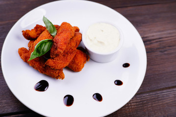 Deep-fried battered chicken nuggets with garlic sauce, popular beer snack. Oktoberfest food, pub, bar, restaurant concept