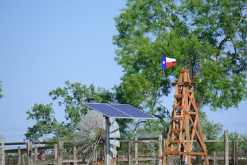 Solar Water well with Texas Windmill, in front of green trees and blue sky
