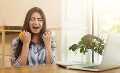 Euphoric shopper buying online with laptop and credit card