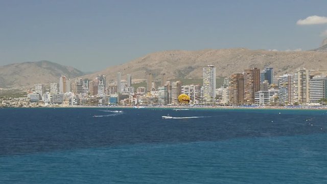 Parasailing on sea coast city skyline background