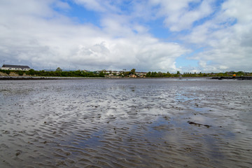 Ballyloughane Beach with houses in background and cloud reflection