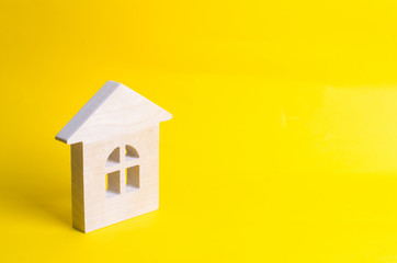 Fototapeta na wymiar Wooden house on a yellow background. Concept of buying and selling housing, building a house. Rent of apartments. Realtors. Real estate, private property, repair and renovation.