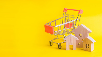 A supermarket cart and a house on a yellow background. Buying and selling of real estate,...