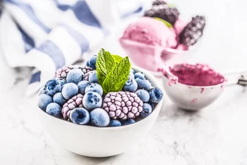 Zelfklevend Fotobehang Close-up frozen blueberries and blackberries and icecream with mint leaves © weyo